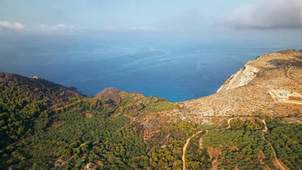 Aerial drone view of nature of Zakynthos, Greece. A lot of greenery, low hills, sunset, Ionian sea alt