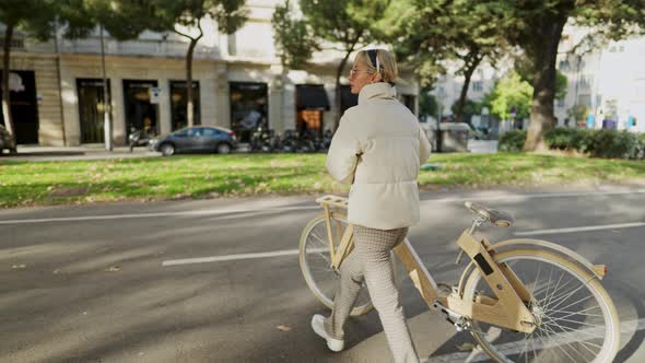 Female Cyclist Crossing Road in City alt