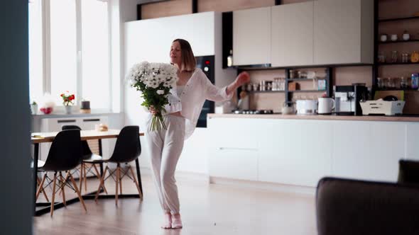 Beauty Delicate Woman Enjoys a Bouquet of White Flowers