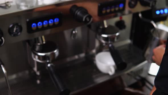 Blur coffee maker machine with barista working at counter in cafe, can be used for background