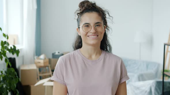 Portrait of Cheerful Asial Woman Smiling Looking at Camera in New Apartment After Relocation alt