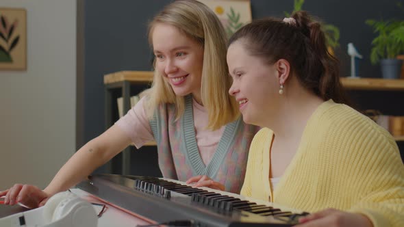 Woman and Girl with Down Syndrome Playing Synthesizer Together alt