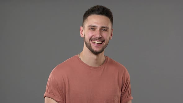 Portrait of Positive Brunette Man Wearing Casual Tshirt Laughing and Expressing Happy Emotions alt