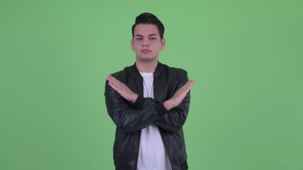 Serious Young Handsome Multi Ethnic Man with Stop Gesture alt