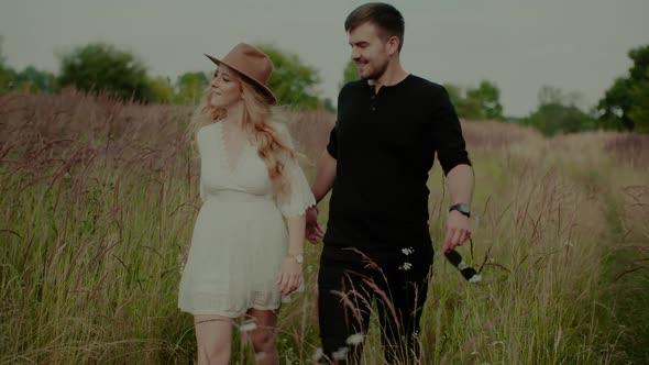 Affectionate Hipsters Walking and Smiling in Summer at Sunset alt
