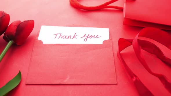 Thank you Message Gift and Tulip Flower Envelope on Red Background alt