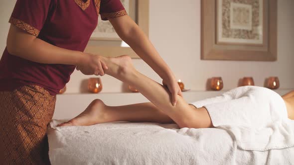 Female Therapist Reliefs Woman's Pain in Legs