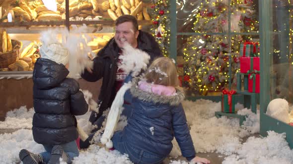 Kids Throwing Fake Snow at Father in Christmas Evening