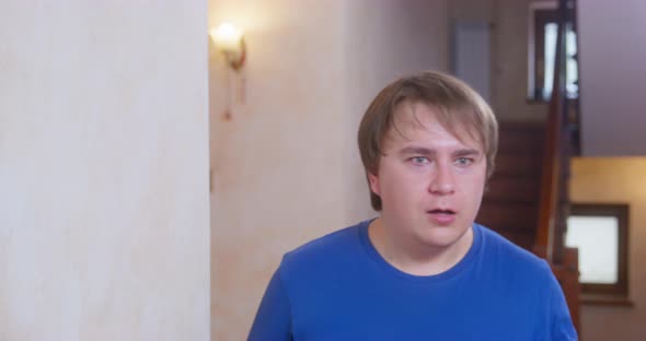 Young Man in a Panic Runs Into the Room and Turns His Head From Side to Side Looking Around and alt