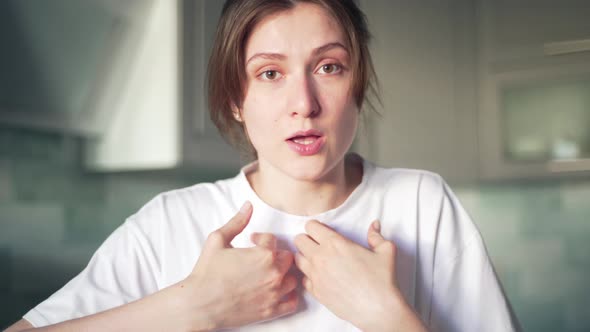 A Young Female Blogger Speaks and Looks Into the Camera, in the Background of the Kitchen. The Girl alt