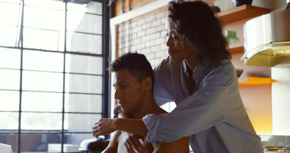 Woman hugging from behind while man using laptop 4k alt