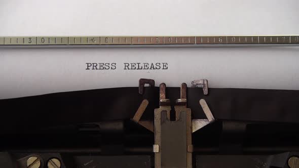 Typing phrase Press Release on retro typewriter. Close up. alt