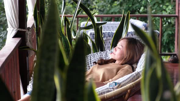 A young asian woman lying in sofa on balcony