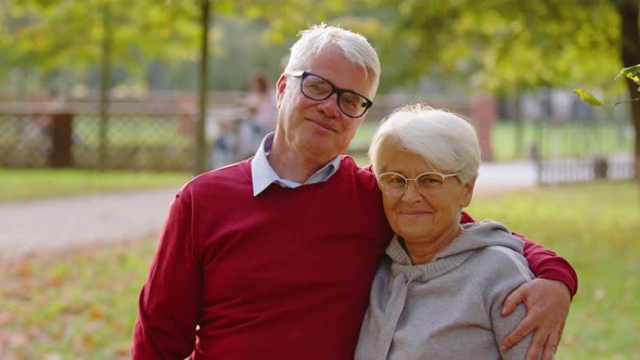 Elderly Pensioner Husband Embracing His Beloved Wife and Smiling to the Camera alt