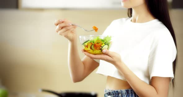 Pretty Asian Woman Eats a Salad of Fresh Vegetables