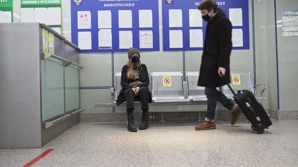 Airline Passengers with Medical Mask in an Airport Social Distancing Sitting Lounge Waiting for alt