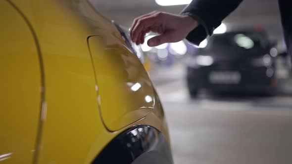 Slow Motion person charging an electric vehicle in underground car park