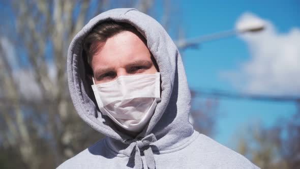 Guy in a medical mask and hood looking straight at the camera. COVID-19 or coronavirus 2019 concept alt