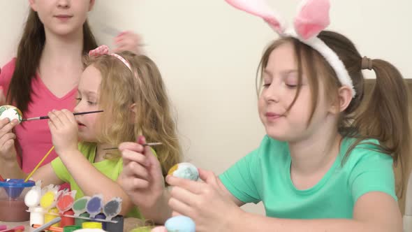 The Girls Help Each Other Paint Easter Eggs