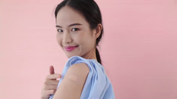 Young Asian Woman Showing COVID19 Vaccine Bandage Merrily alt