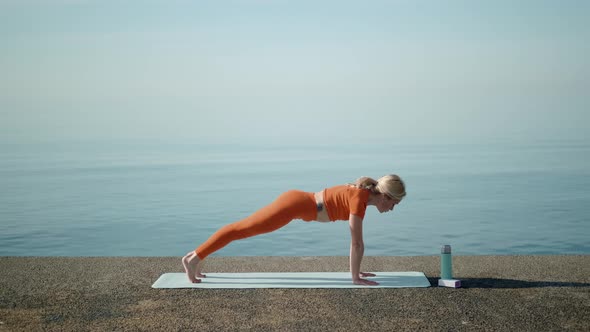 Early Morning Training at the Sea a Woman Enjoys Sports Yoga