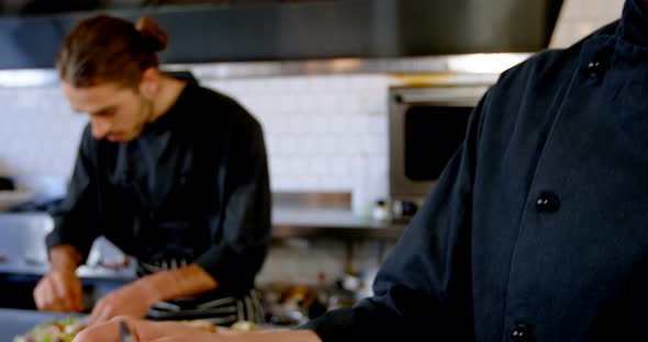 Chef looking at clipboard while talking on mobile phone 4k alt