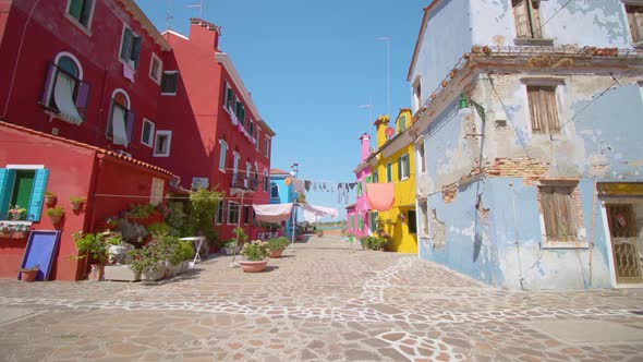 Street with Clothes Drying in Wind Between Colorful Houses alt