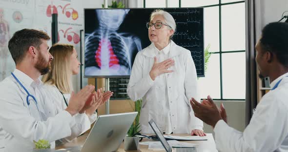 Female Doctor Thanking for Applauses from Her Qualified Motivated Multiethnic Colleagues alt