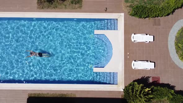 Man Swimming in the Pool Top Down View alt