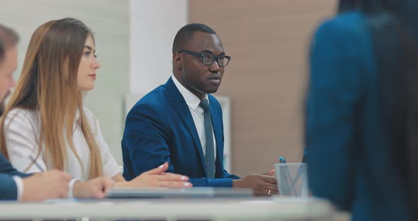 Darkskinned Colleague is Explaining to His Colleagues New Business Development Strategies alt