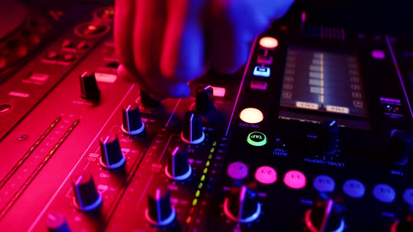 Closeup fingers of sound engineer tuning fader on mixing console. DJ adjusts volume on equipment alt