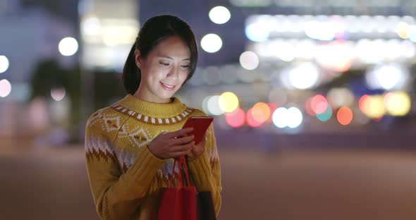 Woman Hold with Shopping Bag and Use of Mobile Phone in City  alt