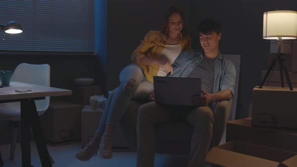 Couple in their new home connecting with a laptop