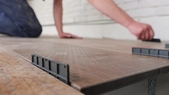 Carpenter Sets Spacing of Deck Boards on Floor Wood Panel