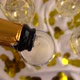 Pouring from a bottle of sparkling wine into glasses on a background of confetti. Slow motion. - VideoHive Item for Sale