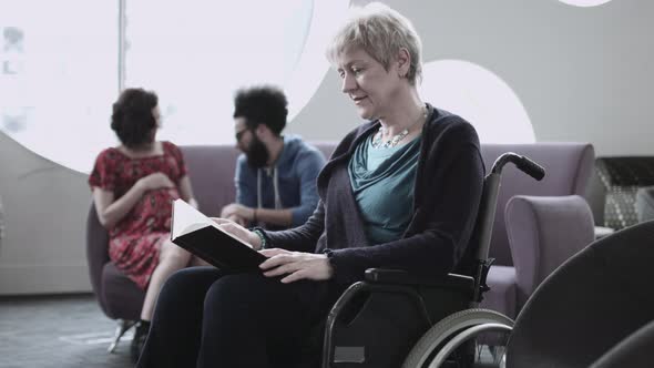 Disable woman in wheelchair reading book