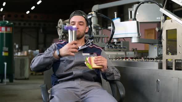 A young man takes food at workplace during work hours or during his lunch break alt