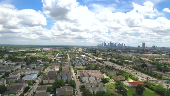Side flight over a major highway in sight with the city's downtown in the background alt