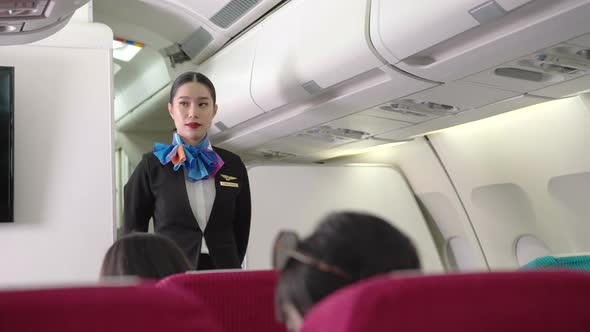Female air hostess watching and checking passenger ready on airplane before takeoff