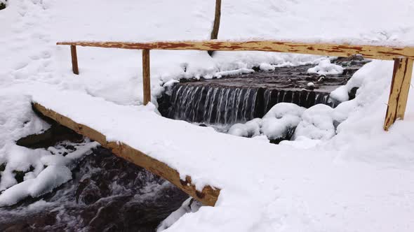 Wooden Bridge Over a Mountain Stream in a Forest Valley in the Carpathian Mountains alt