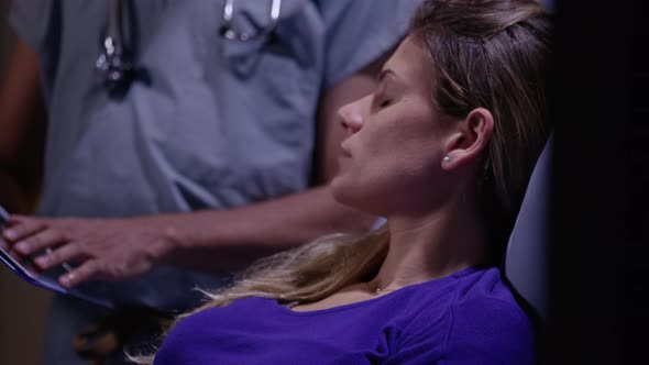 Woman in hospital bed listens to doctor