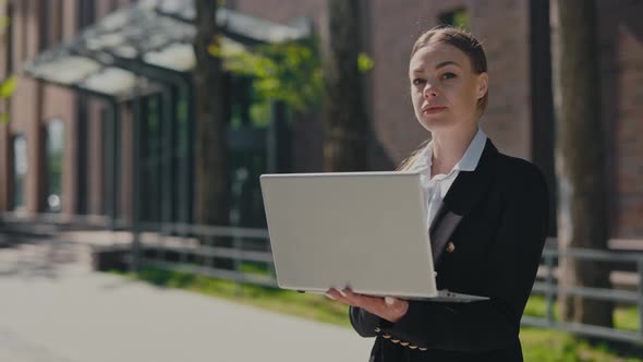 Business Woman with Laptop Posing Outdoors alt