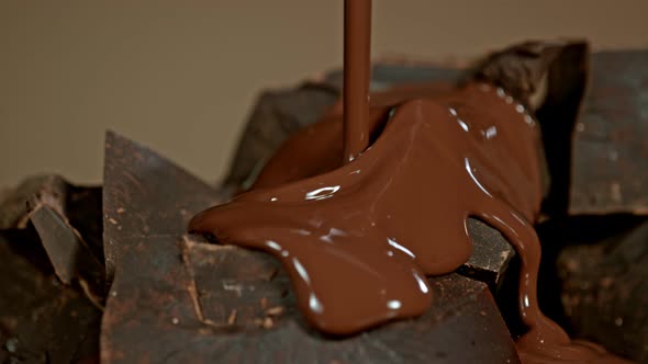 Super Slow Motion Shot of Pouring Melted Chocolate on Raw Chocolate Chunks at 1000 Fps. alt