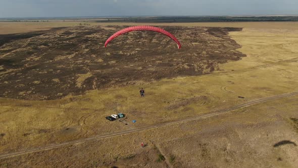 A Person Is Gliding in the Air Above the Beautiful Hills Near the Sea alt