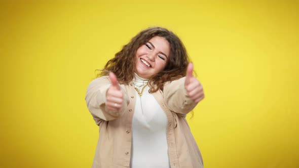 Happy Excited Young Overweight Woman Showing Thumbs Up Looking at Camera Smiling alt
