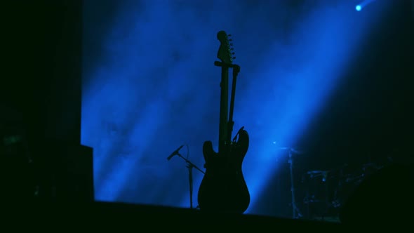 Empty Stage with Instruments Ready for Performance Drums Set Guitars Bass and Music Desk Fog Smoke alt