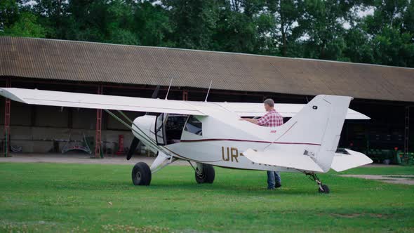 Pilot Checking Private Plane Standing Green Airfield alt