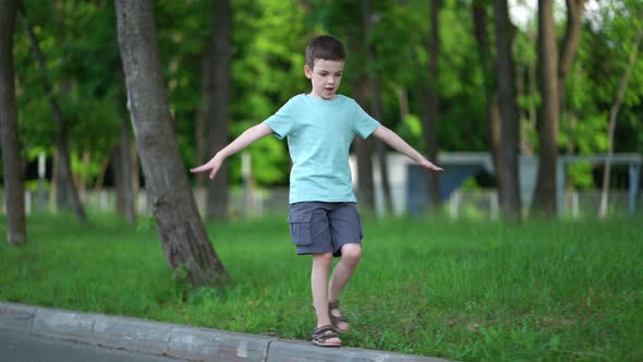 Schoolboy Walks on the Road Curb alt