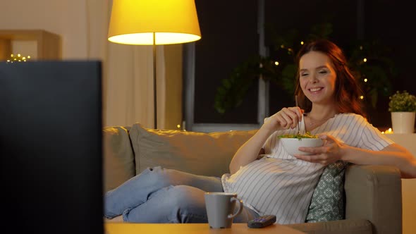 Happy Smiling Pregnant Woman Watching Tv at Home alt