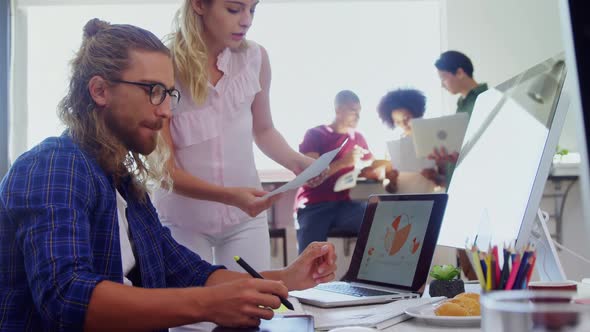 Executives discussing over desktop pc at desk 4k alt